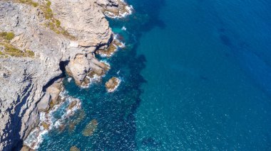 Akdeniz 'in canlı turkuaz sularıyla buluşan kayalık uçurumların nefes kesici manzarası. La manga del mar menor, çarpıcı bir yaz mevsimi.