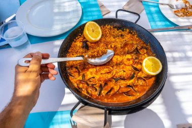 Yaz tatili boyunca el ele tutuşup açık hava restoranında deniz ürünleri kepçesi kepçelemek.