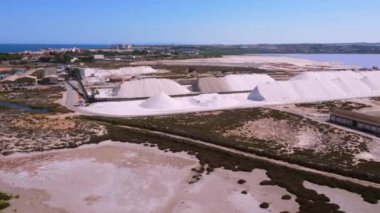 Tuz taşıyan konveyör bandı, güneşli mavi gökyüzünün altında, İspanya 'nın pembe torrevieja gölünün yanında bir tuz madeninde çalışır.