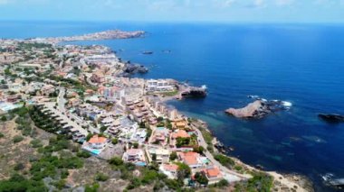Calareona, Murcia 'daki La Manga del Mar Denizi ve binaları aydınlatan güneş ışığı canlı bir sahil manzarası yaratır.