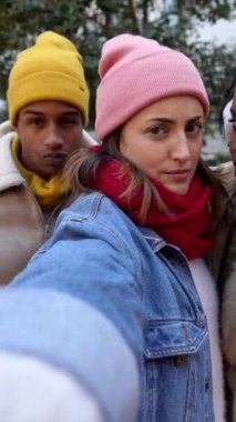 Genç arkadaşlar kış kenti gezisi sırasında neşeli selfie anları yakalıyorlar, kentte beraberlik ve cep telefonuyla kendiliğinden arkadaşlık sergiliyorlar.