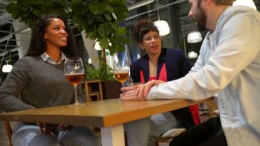 Çok ırklı arkadaşlar gece terasında bira içip eğleniyorlar.