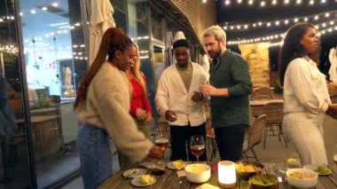 Çok ırklı bir grup genç gecenin bir yarısı bir bar terasında kadeh kaldırıyor.