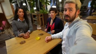 Arkadaşlar bar terasında konuşurken gülüyorlar. Sakin bir gecede bira içip kokteyl içiyorlar.