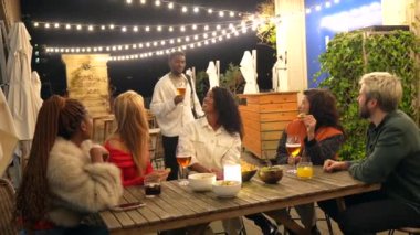 Çok ırklı arkadaşlar, gece bir bara geldiklerinde birbirlerine sarılıyorlar.