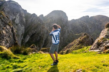 Tourist taking pictures of the landscape of aiako harria or penas de aia, a mountain range located in oiartzun, gipuzkoa, basque country clipart