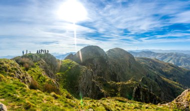 Aiako Harria dağının zirvesinde duran bir grup yürüyüşçü Bask kırsalının çarpıcı manzarasının tadını çıkarıyorlar.