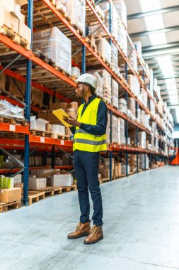 Erkek Afrikalı mühendis büyük bir dağıtım deposunda dijital tablet kullanıyor.