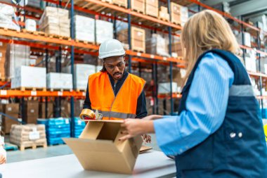 Çok ırklı işçiler dağıtım deposunda paket hazırlıyorlar.