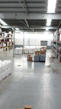 Ticari mallar yavaş yavaş bir lojistik merkezindeki depo alanını dolduruyor, verimli depolama ve organizasyon uygulamaları sergiliyor