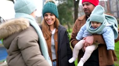 Aile, neşeli kış anlarının tadını çıkarıyor, gülüyor ve kaynaşıyor. Sıcak aile sevgisinin ve çocukluk sevincinin olduğu karlı park manzarasının ortasında.