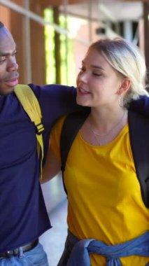 Üniversite boyunca yürüyen çok ırklı Afrikalı ve beyaz bir çift.