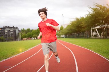 Kafkas yoğunlaştırılmış genç adam eğitimi açık hava pistinde koşuyor.