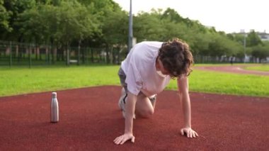 Pistte koşmadan önce ısınan ve esneyen bir adamın tam uzunluktaki videosu