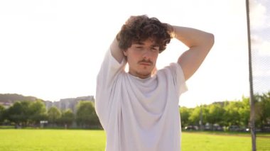 Genç beyaz adam koşuya çıkmadan önce bacaklarını esnetiyor.