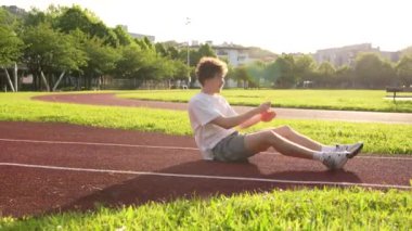 Genç beyaz adam koşuya çıkmadan önce bacaklarını esnetiyor.