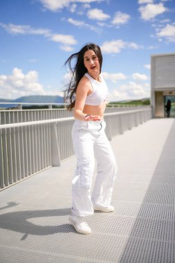 Beyaz tenli güzel bir kadının dikey boyu dans eden şehir müziğini harekete geçiriyor.