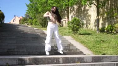 Alçak açılı hareketli şehirde dans eden beyaz bir kadının dans ederken çekilmiş fotoğrafı.