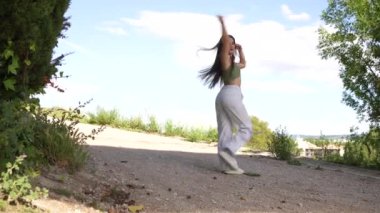 Yaşamsal güzellik, beyaz kadın, şehir parkında dans ediyor.