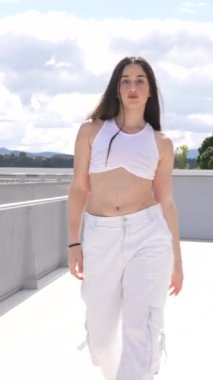 Beyaz tenli güzel bir kadının dikey boyu dans eden şehir müziğini harekete geçiriyor.