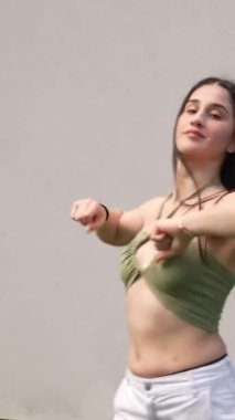 Parkta modern müzik eşliğinde dans eden enerjik, beyaz, güzel bir kadın.