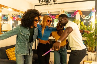 Çok ırklı genç arkadaşlar bir ev partisinde eğlenmeyi bırakıyorlar.