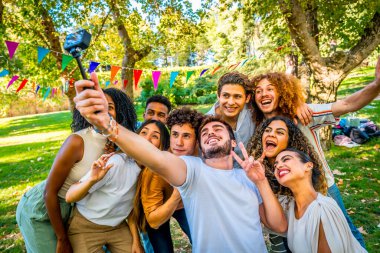 Havalı çoklu etnik arkadaşlar parkta piknik partisinde mutlu mesut selfie çekiyorlar.