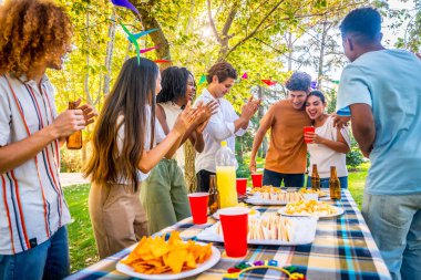 Parktaki partideki çok ırklı arkadaşlarıyla olumlu haberleri paylaşan bir çift