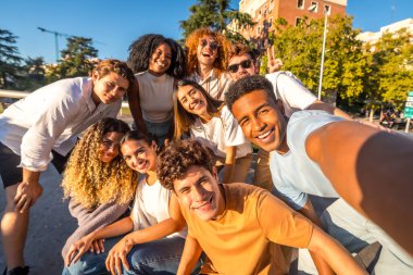 Gün batımında kentte selfie çeken çok ırklı öğrenci grubunun ön görüntüsü