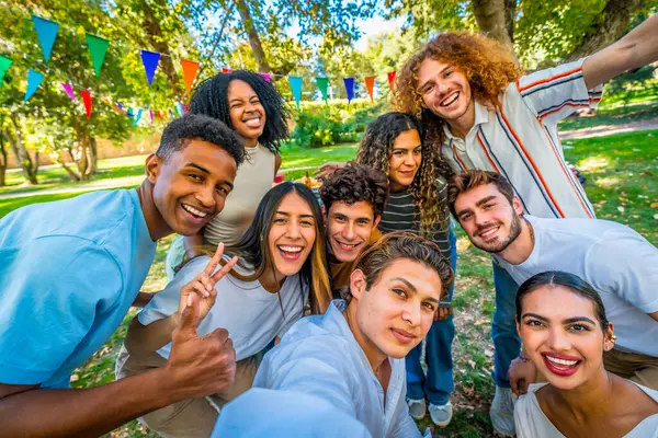 Parkta kutlama partisinde selfie çeken mutlu çoklu etnik öğrencilere ön şahsi bakış açısı