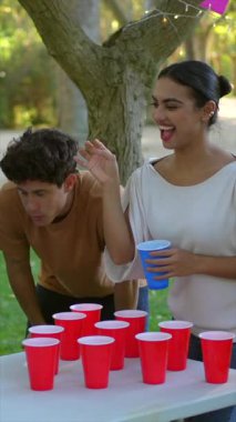 Baharda parkta bira pong oynayan çok ırklı mutlu arkadaşlar.