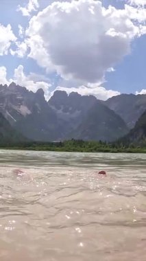 Turistin ayakları lago di landro ya da durrensee gölünün turkuaz suyuna sıçrıyor. Dolomite dağları arka planda, İtalya 'da yaz mevsiminde.
