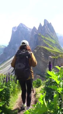 Yürüyüşçü, güneşli bir yaz günü, İtalya 'nın Dolomitler bölgesindeki sıradağların nefes kesici manzarasının keyfini çıkarırken, gözlerini koruyor.