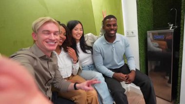 Çeşitli girişim ekibi üyeleri eğlenceli bir selfie anı paylaşıyor, çağdaş çalışma alanında işbirlikçi enerji ve yoldaşlığı yakalıyorlar