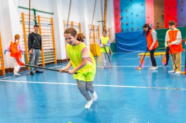 Beden dersinde florbol oynayan ilkokul öğrencileri takım çalışmasını ve sportmenliği fiziksel aktivitelerle öğreniyorlar.