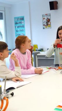 Laboratuvar önlüğü giyen öğrenciler bilimsel deney yapıyorlar, eğitim laboratuvar ortamında kimya dersi sırasında test tüplerinde sıvıyı inceliyorlar.
