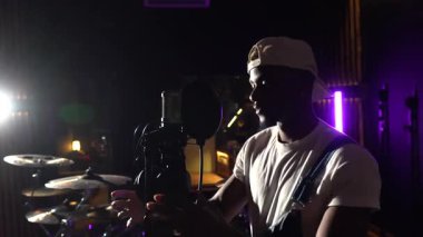 Modern ses stüdyosunda modern müzik parçalarını kaydeden profesyonel müzisyen sanatsal tutku ve adanmışlığı yakalıyor.