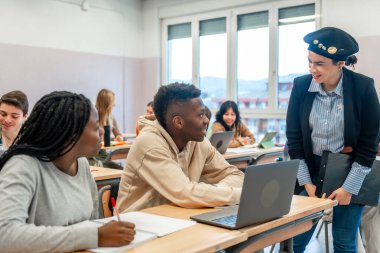 Üniversitedeki bir derste öğretmenlerini dinleyen çok ırklı öğrenciler.