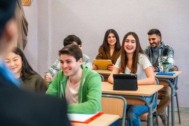 Konferansa katılan ve dijital tabletler kullanan çok ırklı üniversite öğrencileri, öğrenim ve akademik uğraşların keyfini çıkarıyorlar