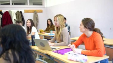 Genç üniversite öğrencilerinin dikkatle dinlediği, akademik dersler sırasında not aldığı ve eğitmenlerin eğitim içeriğiyle ilgilendiği profesyonel sınıf ayarları.