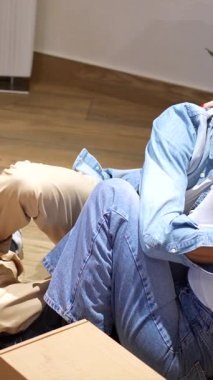 Genç çift bavullarını boşaltmaya ara veriyor, yeni evlerindeki karton kutuların arasında hassas bir anı paylaşıyorlar.