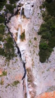 Rina şelalesini görüntüleyen hava manzarası yemyeşil ve kayalık uçurumlarla çevrili logarska dolina vadisine dökülüyor.