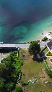 Hava görüntülerinde Vaftizci Aziz John Kilisesi ve Slovenya 'daki Bohinj Gölü üzerinde taş bir köprü sergileniyor.