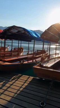 Pletnas olarak bilinen ahşap turist tekneleri, göldeki bir rıhtımda demirlediler, Slovenia 'da kanları aktı, güneşin altın ışığında yıkandılar.