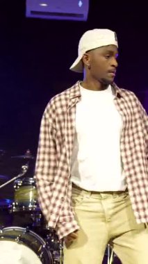 Profesyonel kayıt stüdyosunda müzik enstrümanlarıyla çevrili, dinamik hip hop hareketleri yapan yetenekli dansçı, tutkulu şehir ritmini ifade ediyor.