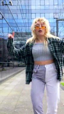 Modern bir şehir ortamında özgürce dans eden enerjik genç kadın dinamik hareketlerle kendini ifade ediyor.