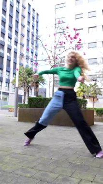 Genç bayan dansçı modern şehir sokak dansı ile enerjik enerjisini ifade ediyor, şehir planına karşı dinamik koreografi sergiliyor.