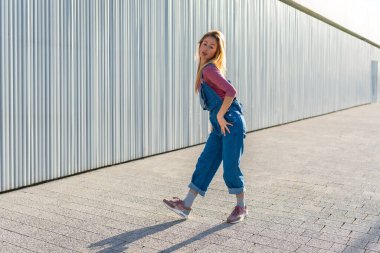 Açık havada dans eden yetenekli sarışın kadın enerjik hareketlerini ve sokak dansı tutkusunu sergiliyor.