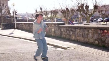 Enerjik genç dansçı şehir sokaklarında hareketli hip hop hareketleri sergiliyor, akışkan hareketler ve sanatsal tarzla tutkuyu ifade ediyor