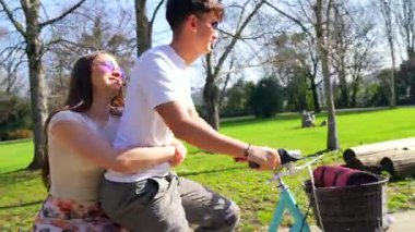 Sevgili çift, yemyeşil parklarda yan yana pedal çeviriyor, samimi anları paylaşıyor ve güneşli öğleden sonra gezintisinde uzun süreli anılar yaratıyor.